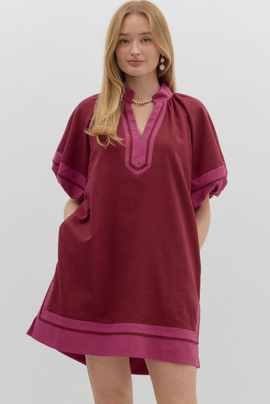 Woman wearing the Merlot & Magenta Muse Dress, a short sleeve tunic in deep merlot with magenta contrast trim, V-notch neckline, and side pockets – Milo & Lily Boutique.