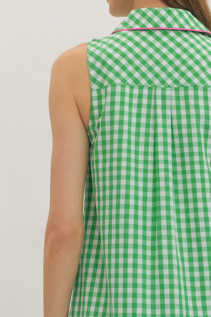 Green and white checkered sleeveless top worn by a person on a plain background