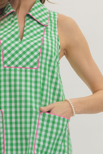 Green and white checkered dress with pink trim on a plain background