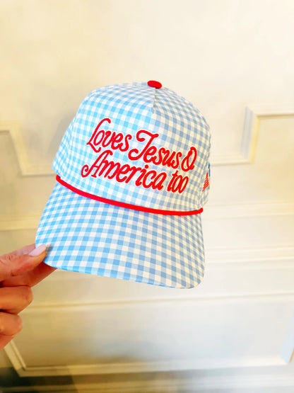 Blue and white checkered cap with red text held by a hand against a neutral background