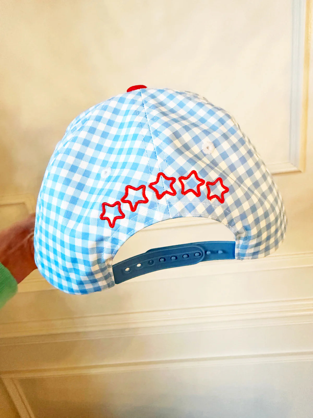 Blue and white checkered cap with red stars on a light-colored surface