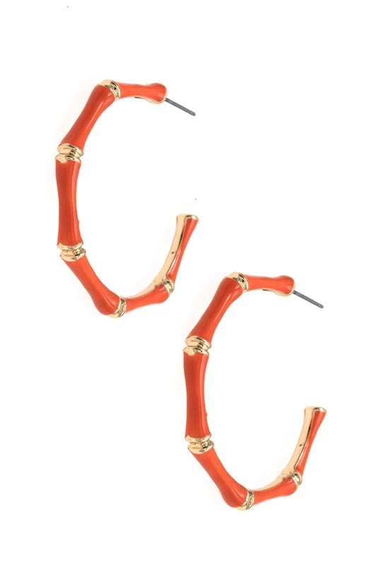 A pair of hoop earrings designed to look like red-orange bamboo stalks with gold-colored nodes, shown on a plain white background.