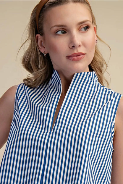 Woman wearing a blue and white striped sleeveless top against a beige background