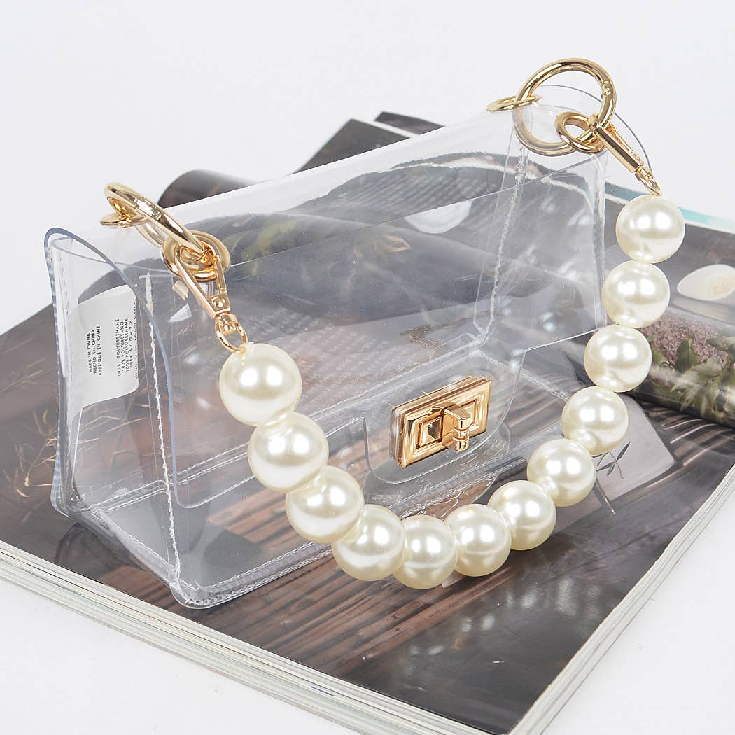 Pearl bracelet with gold clasp on a clear handbag