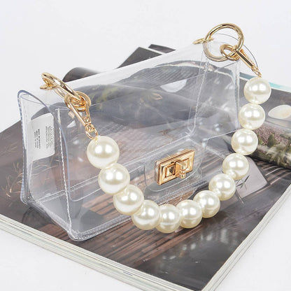 Pearl bracelet with gold clasp on a clear handbag