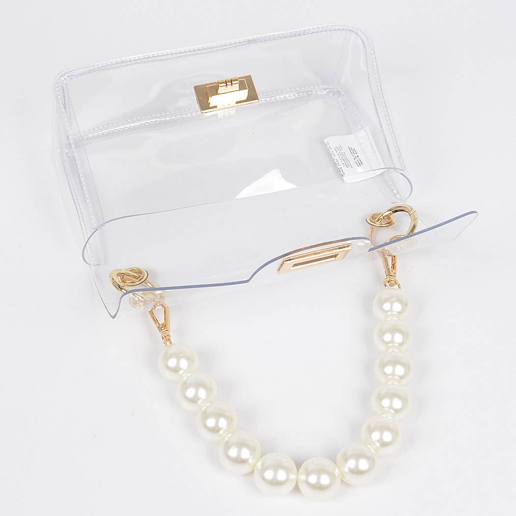 Pearl necklace with gold clasp on a clear stand against a white background