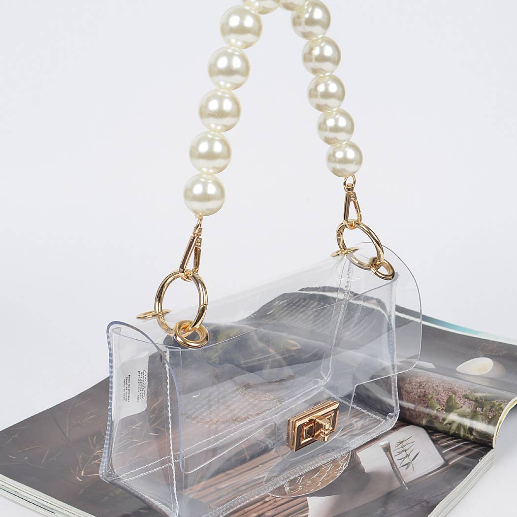 Clear handbag with pearl handle on a white surface