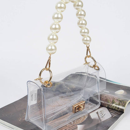 Clear handbag with pearl handle on a white surface