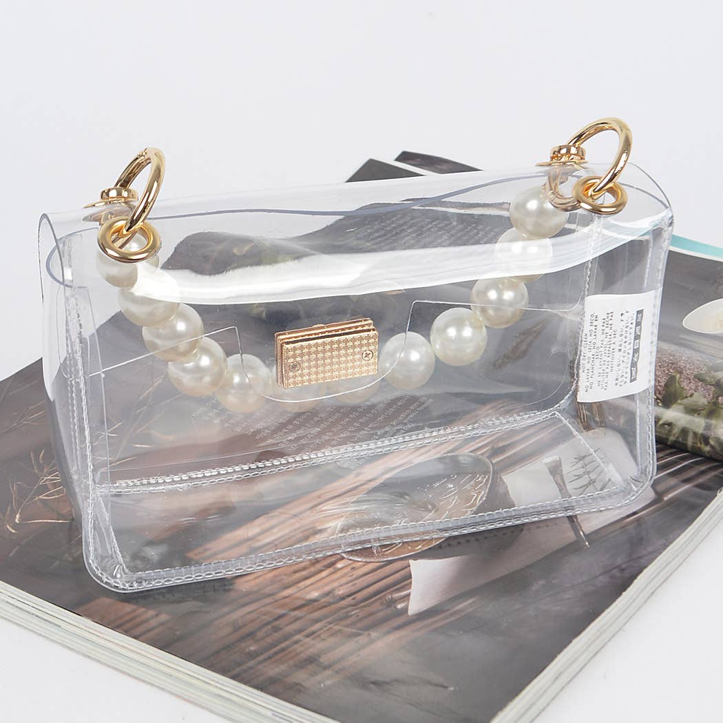Clear handbag with pearl handle on a magazine