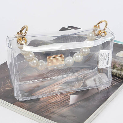 Clear handbag with pearl handle on a magazine