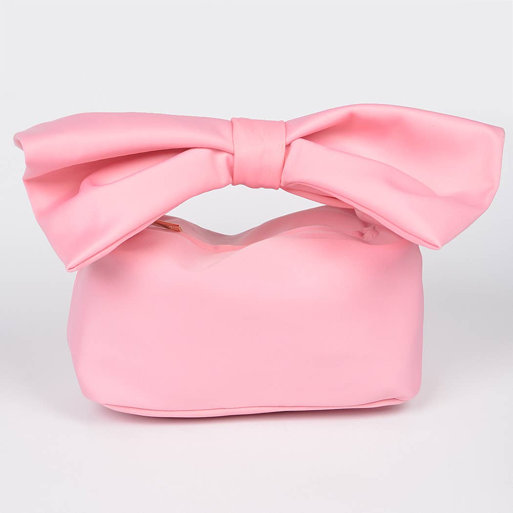 Pink handbag with a large bow on a light gray background