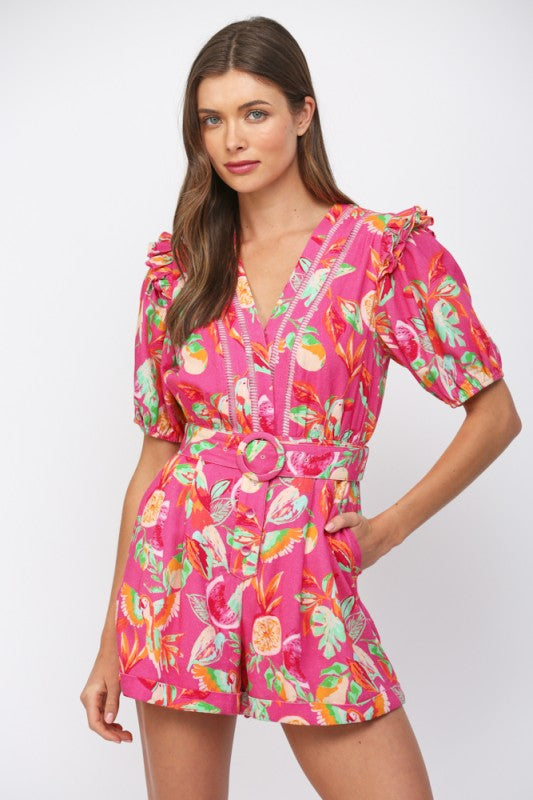 Woman wearing a colorful floral romper on a white background