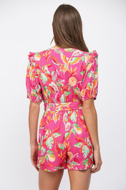 Woman wearing a pink floral jumpsuit on a white background