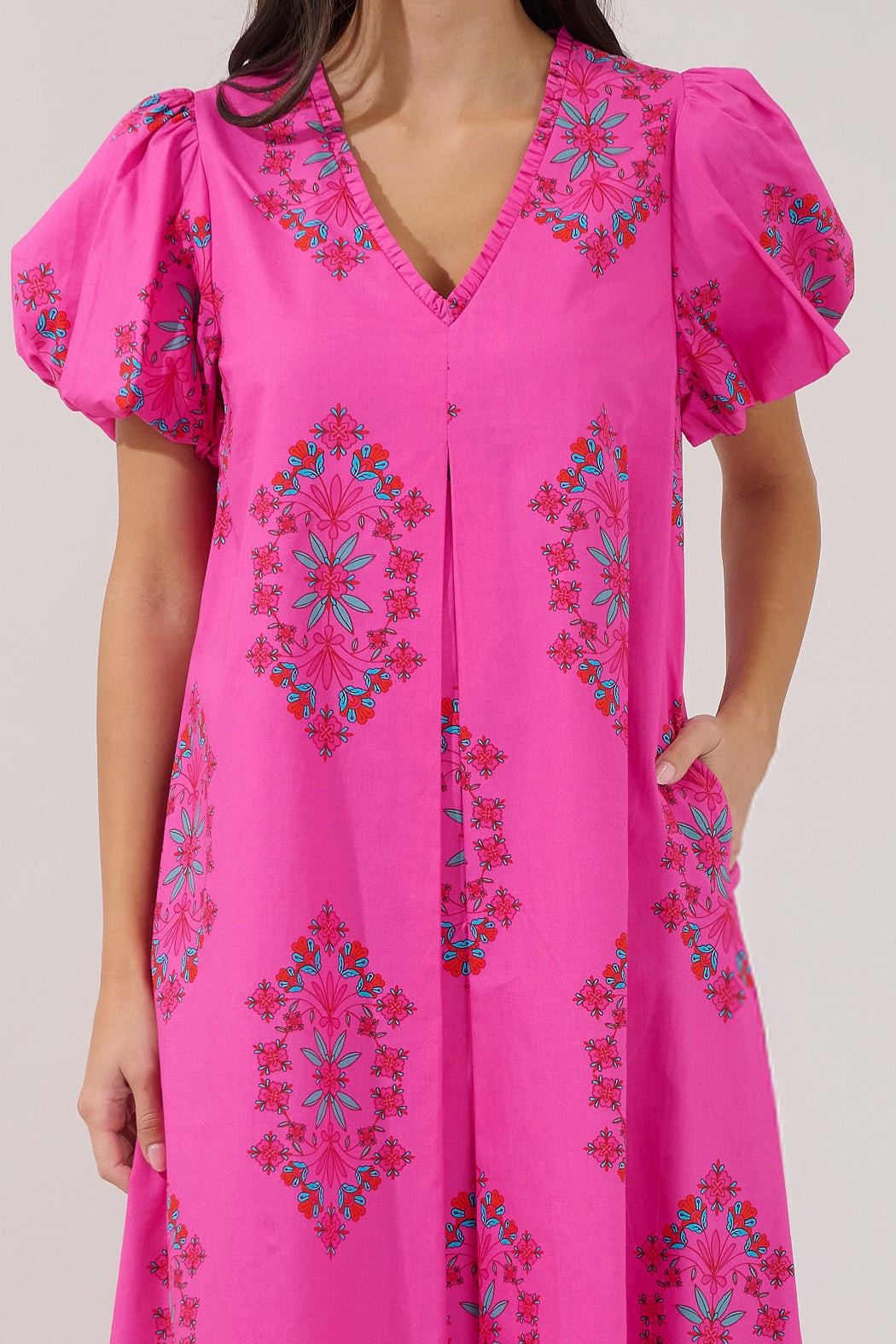 Pink dress with colorful embroidery on a plain background