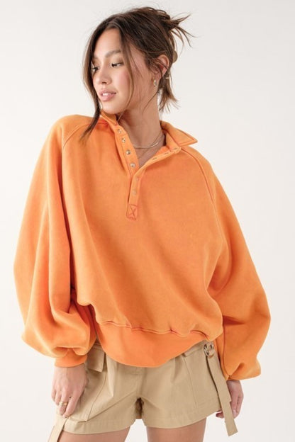 Person wearing an orange fleece pullover with a white background