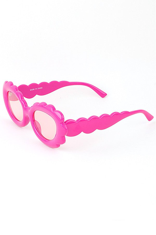 Bright pink scalloped sunglasses with round lenses and playful wavy frames, women's accessory