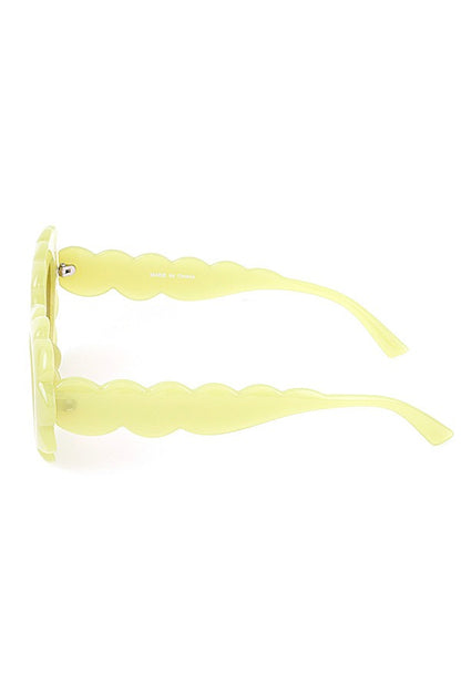 Yellow scallop-edge sunglasses with wavy arms, side profile on white background