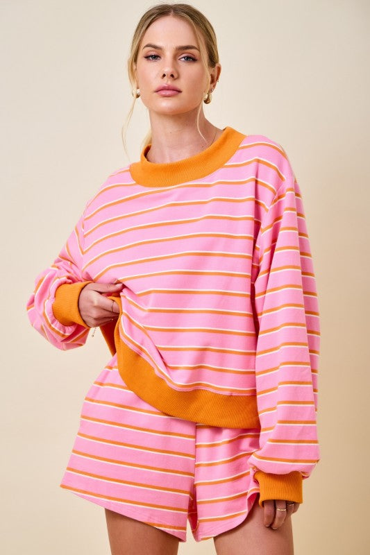 Woman wearing a pink and orange striped outfit on a beige background