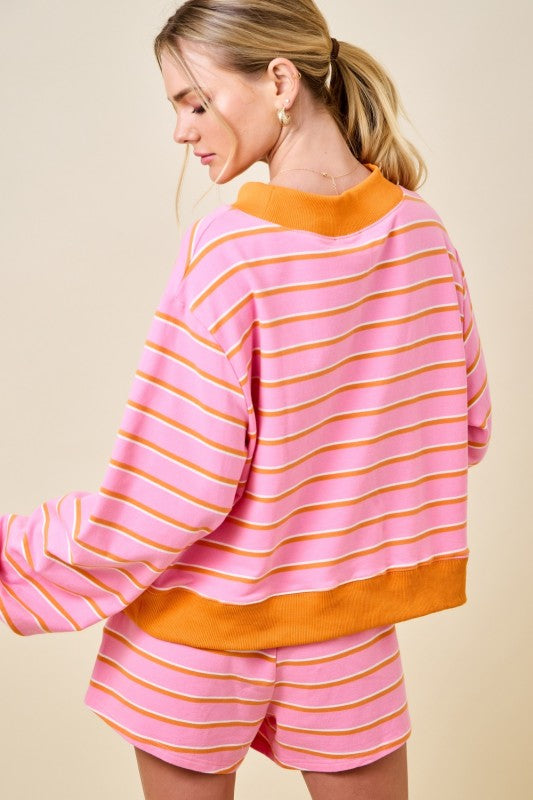Person wearing a pink and orange striped outfit on a beige background
