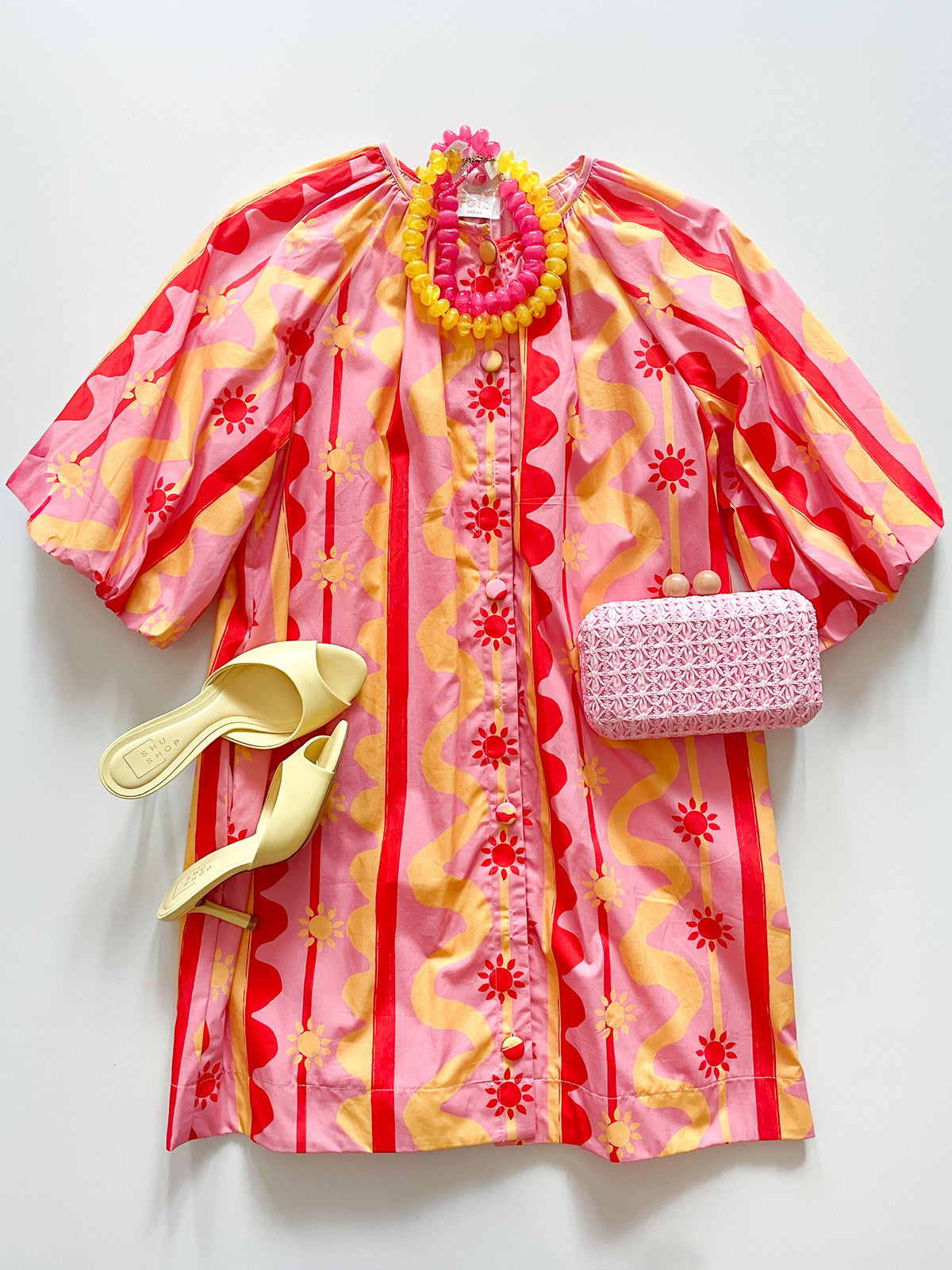 Colorful dress with matching accessories on a white background