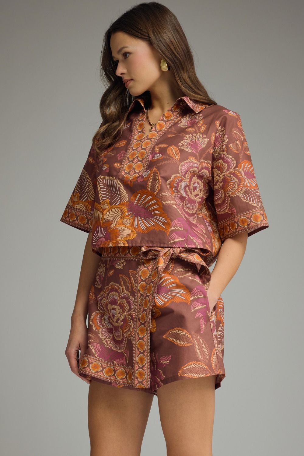 Side view of terracotta floral matching set featuring short sleeve cropped top and tie-waist skort in orange and pink floral print.