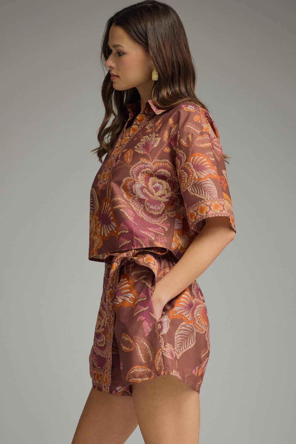 Side view of terracotta floral matching set featuring short sleeve cropped top and tie-waist skort in orange and pink floral print.