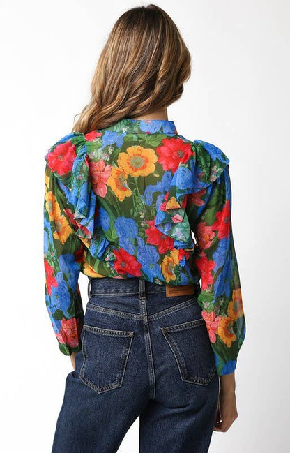 Person wearing a colorful floral jacket and blue jeans on a white background