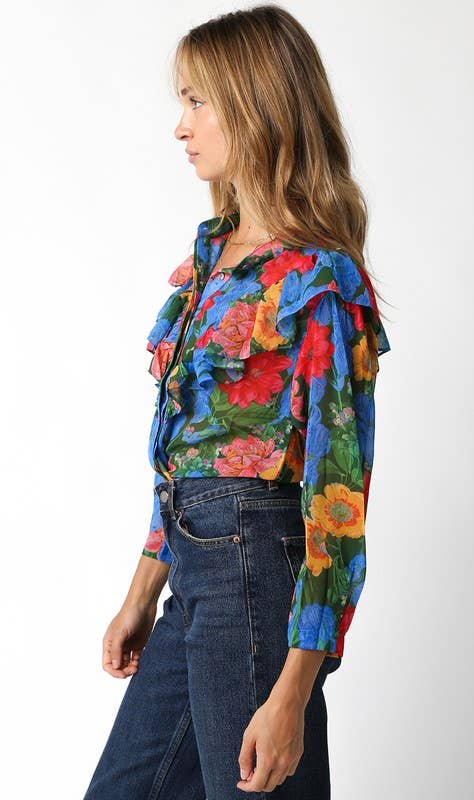 Woman wearing a colorful floral jacket and blue jeans on a white background