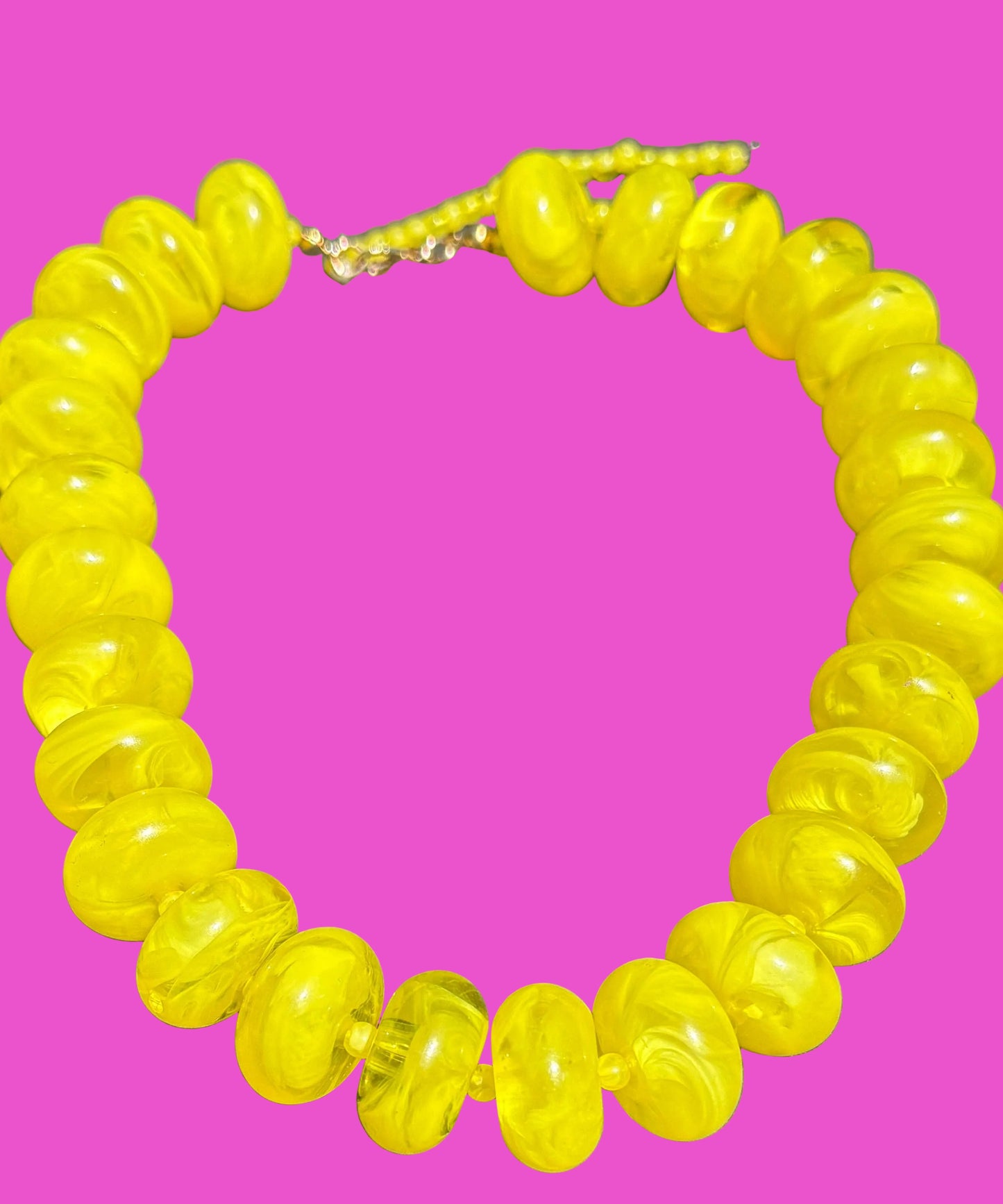Yellow beaded necklace on a pink background