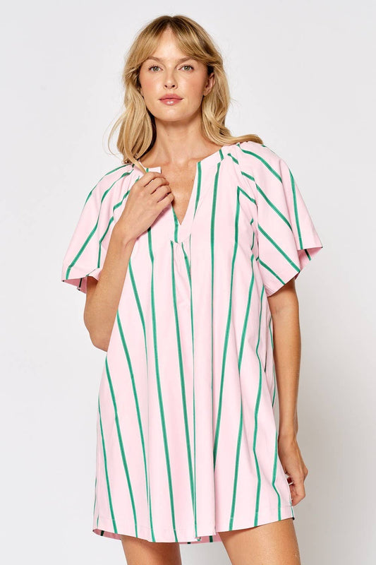 Woman wearing a pink and green striped dress on a white background