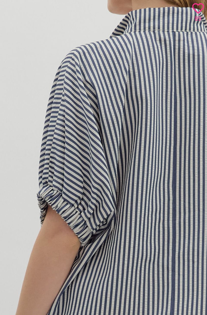 Navy and white striped shirt worn by a person on a plain background