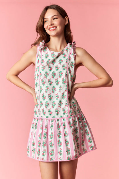 Woman wearing a floral dress on a pink background