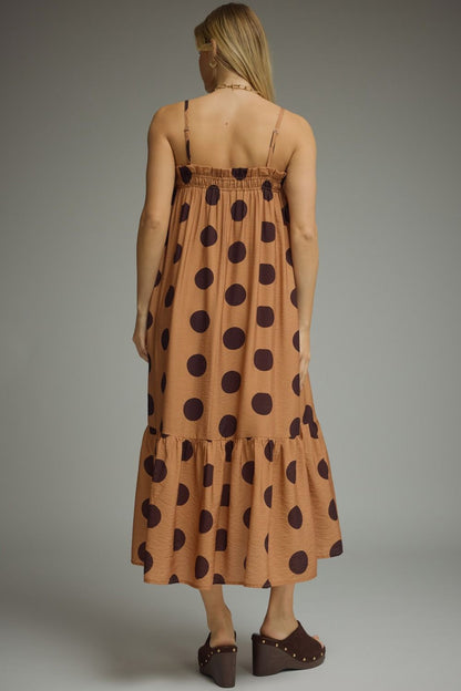 Woman wearing a polka dot dress with a plain background