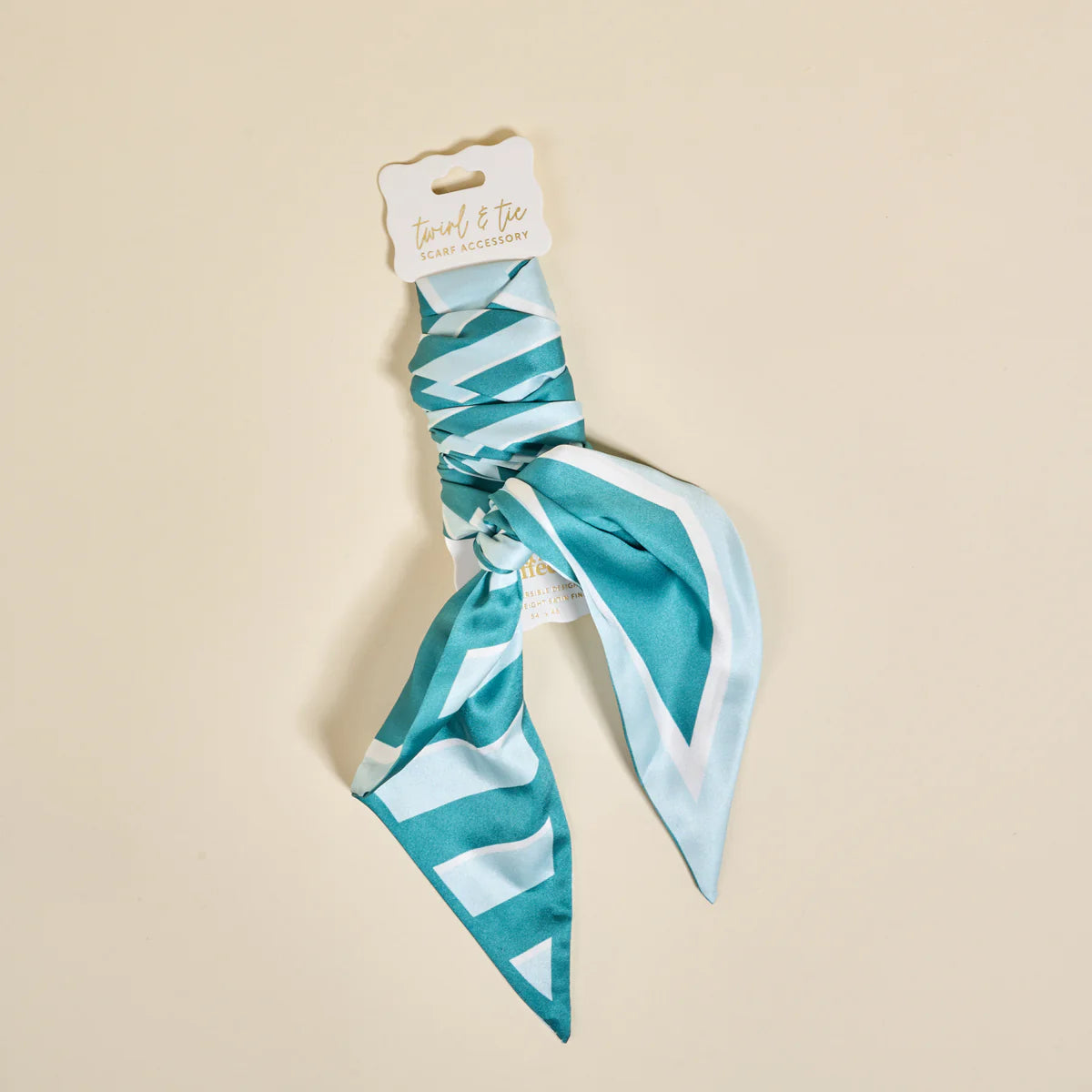 Teal and white patterned hair scarf on a beige background