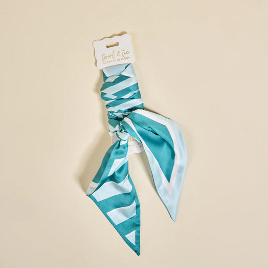 Teal and white patterned hair scarf on a beige background