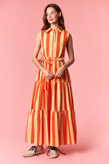 Woman wearing a orange and yellow striped dress on a pink background