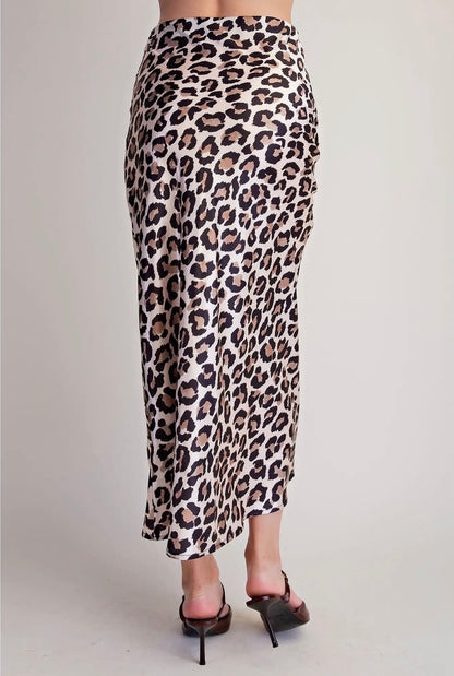 A leopard print midi skirt with a beige, brown, and black pattern, shown on a model from the back against a light gray studio background.