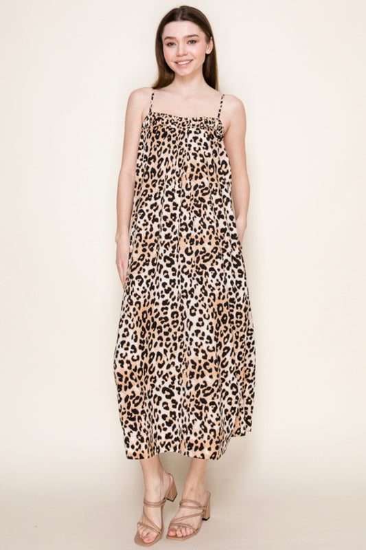 Woman wearing a leopard print dress on a plain background