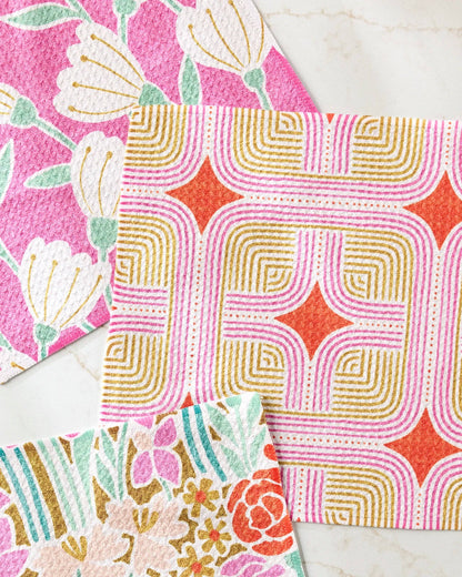 Colorful floral and geometric patterned dishcloths on a marble surface