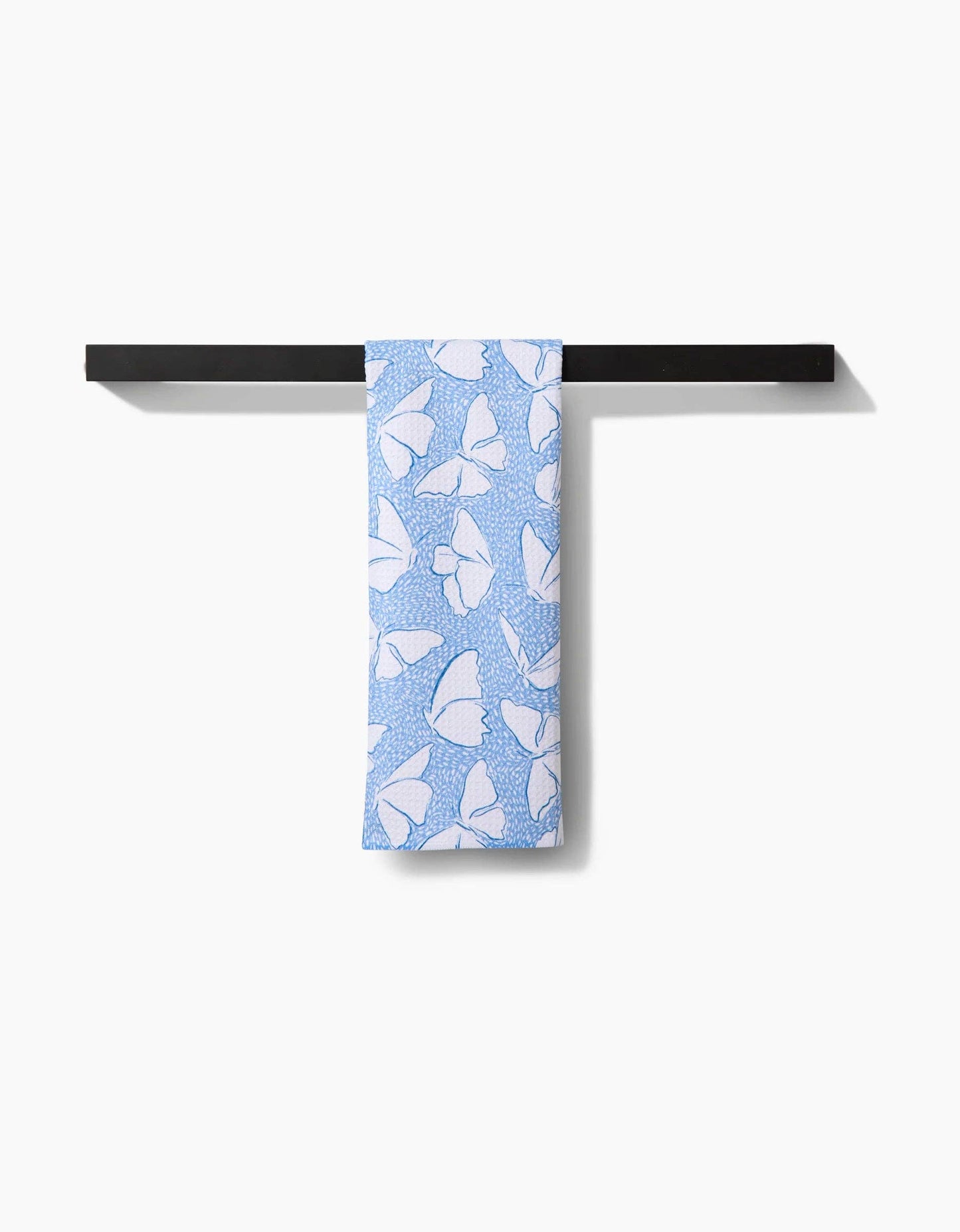 Light blue scarf with white butterfly print hanging on a black rod against a white background.