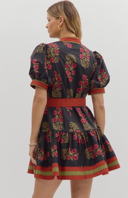 Back view of black floral mini dress featuring puff sleeves, red trim, and flattering belted waist — boutique fall floral dress from Milo & Lily Boutique.
