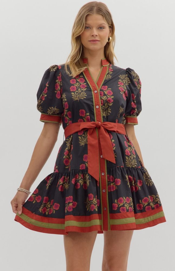 Model wearing a black floral mini dress with puff sleeves, red waist tie, and button-down front — elegant fall boutique dress from Milo & Lily Boutique.