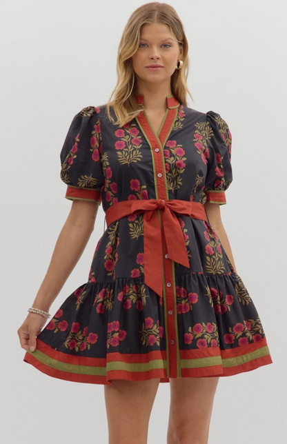 Model wearing a black floral mini dress with puff sleeves, red waist tie, and button-down front — elegant fall boutique dress from Milo & Lily Boutique.