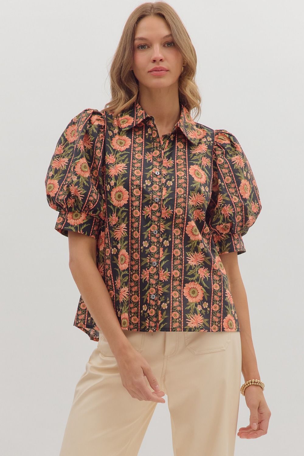 Model wearing a black puff sleeve blouse with coral and olive floral print and button front — elegant boutique top from Milo & Lily