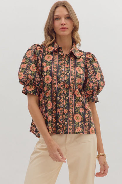 Model wearing a black puff sleeve blouse with coral and olive floral print and button front — elegant boutique top from Milo & Lily
