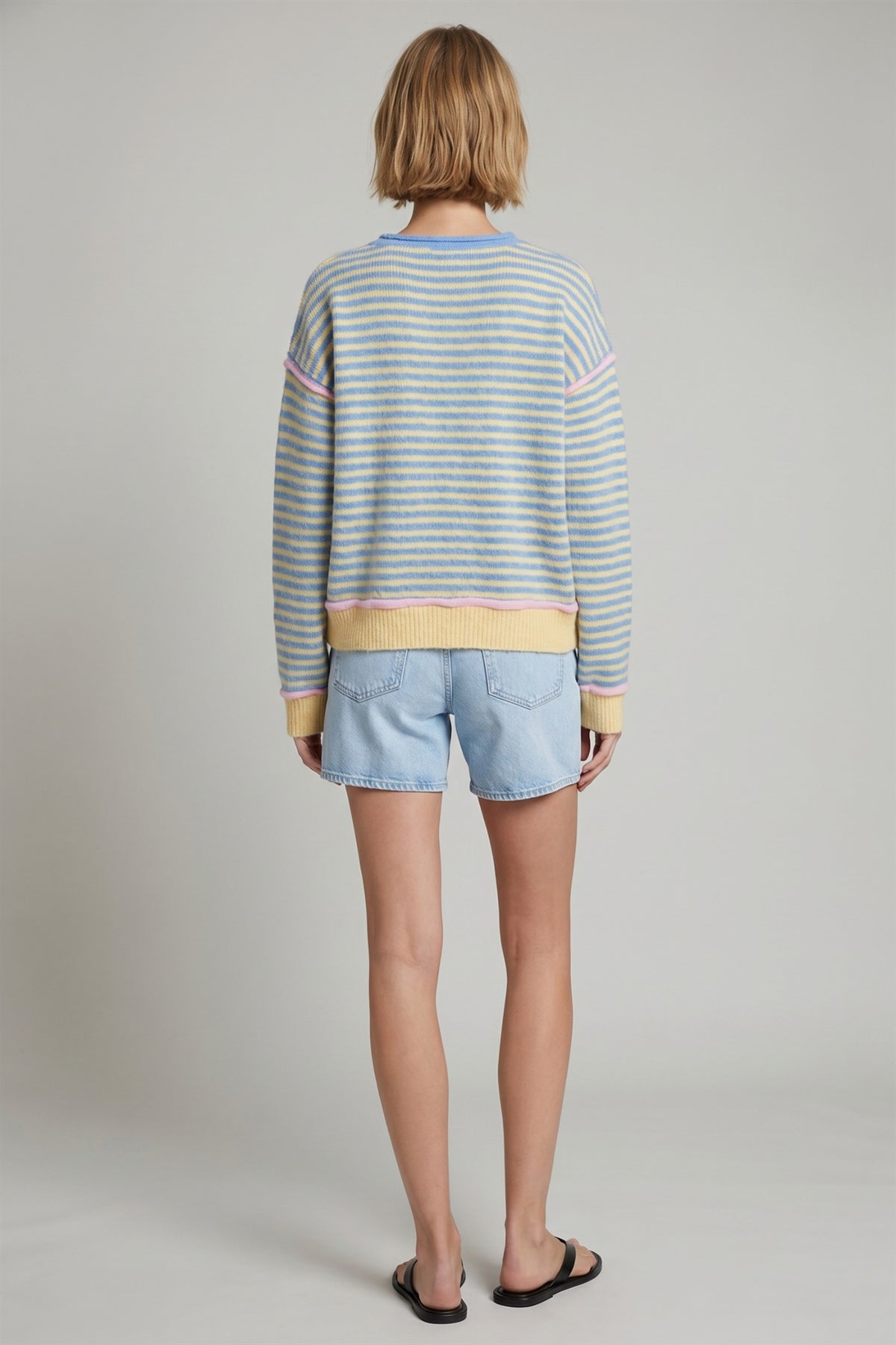 Back view of blue and yellow striped pullover sweater with pink trim.