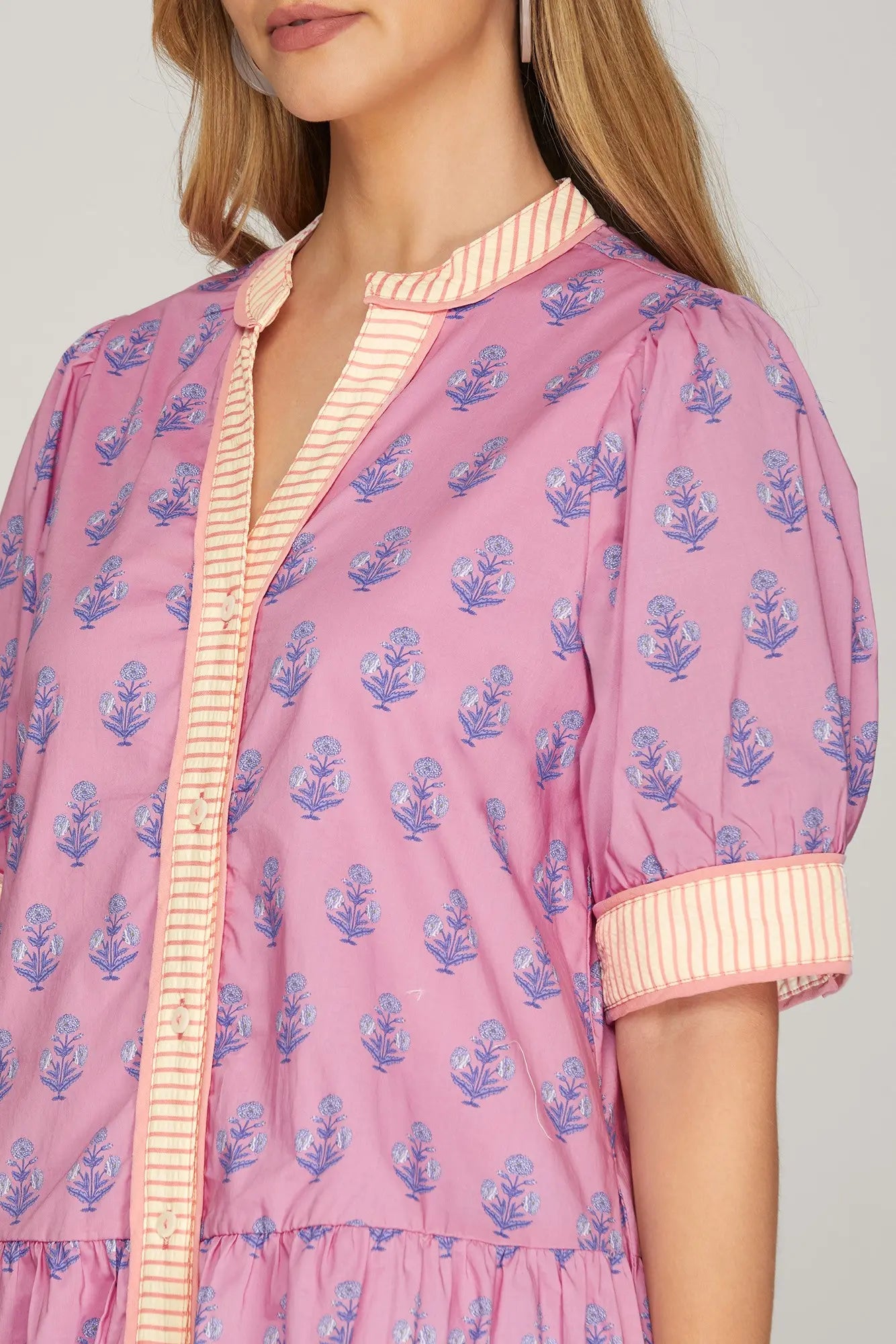 Pink floral patterned blouse with a plain background