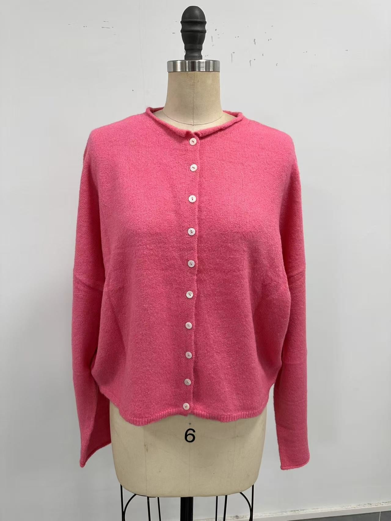 Pink cardigan on a mannequin against a white background