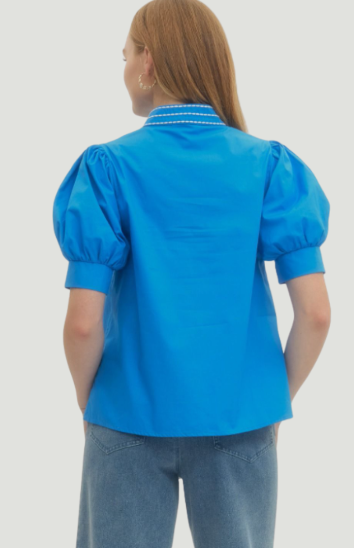 Person wearing a blue blouse with puffed sleeves on a white background