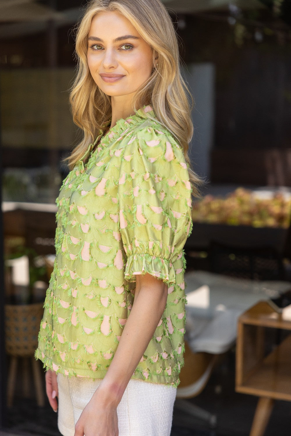 Side view of The Citrus Scallop Blouse with puff sleeves and blush underlay detail.